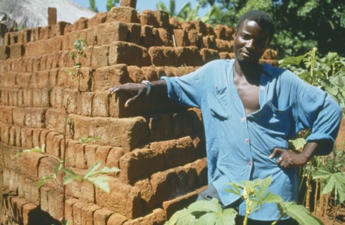 MALAWI, Mulanje, Portrait of man standing next  to brick building in a Ekhamuru Village.