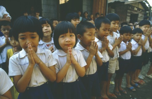 THAILAND, Tap Gaen, Line of school children giving traditional Thai greeting or wai with palms