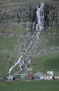 DENMARK, Faeroe Islands, Torshaven, Waterfall and village.