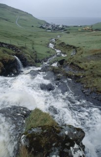 DENMARK, Faeroe Islands, River Gazadalla, Fast flowing rocky river with village and coastline