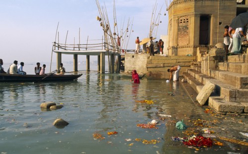 INDIA, Uttar Pradesh, Varanasi, Scum and remnants of flower offerings float around the steps of the