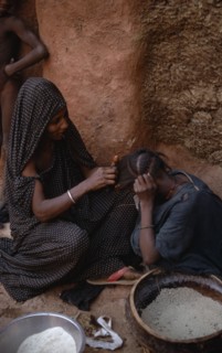 MAURITANIA, Oualata, Woman braiding the hair of another.