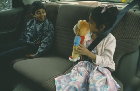 ENGLAND, London, Children, Two Bengali children in back seat of car wearing seat belts.  Young girl
