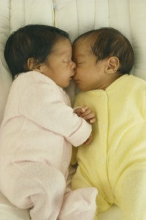 CHILDREN, Twins, "Seven week old fraternal twins in cot, facing each other with hands and faces