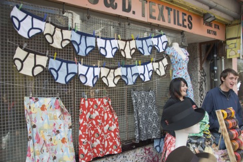 ENGLAND, East Sussex, Brighton, A North Lanes market stall selling hats and clothes with a  large