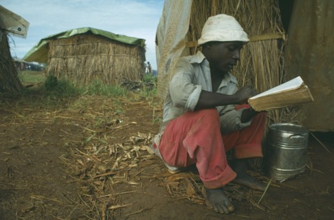 TANZANIA, Heru Oshiuga Camp, Burundian Hutu refugee reading the Bible in refugee camp.