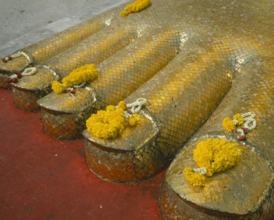 THAILAND, Bangkok, Banglamphu, Wat Indrawiharn. Close up of Floral offerings on the toes of a 45