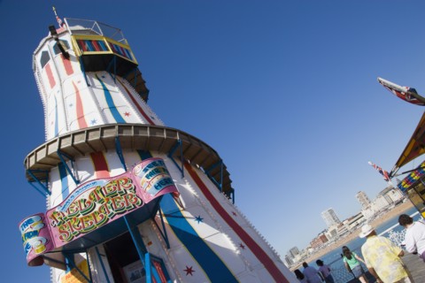 ENGLAND, East Sussex, Brighton, The Helter Skelter ride on Brighton Pier with tourists walking past