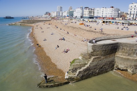 ENGLAND, East Sussex, Brighton, The beach and seafront with flint groyne in the foreground seen