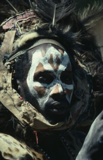 KENYA, Tribal People, Portrait of Kikuyu man with painted face and wearing fur and feather head