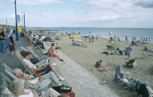 ENGLAND, Dorset, Bournemouth, People sat on deckchairs along seafront