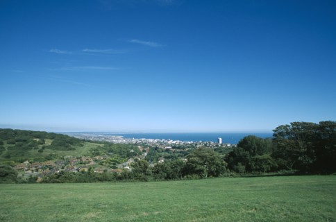 ENGLAND, East Sussex, Eastbourne, Elevated view from the South Downs over fields towards town and
