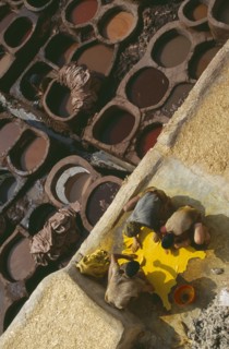 MOROCCO, Fes, Chouwara Tanneries.  Men working at the tanner’s pits with coloured dyes.