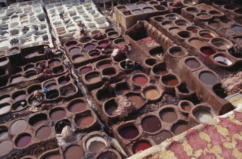 MOROCCO, Fes, Chouwara Tanneries.  Elevated view over men working in the tanner’s pits.