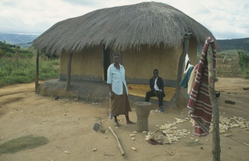 MALAWI, Lumbe, Couple outside thatched home in Wilsan village.