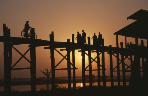 MYANMAR, Amarapura, U Bein Bridge near Mandalay at sunset with silhouetted figures of monks and