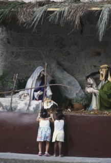 CUBA, Havana, Two young girls admiring a nativity show.