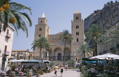 ITALY, Sicily, Palermo, Cefalu. Pathway towards II Duomo Norman Cathedral between cafes with people