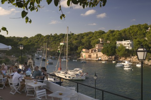 SPAIN, Balearic Islands, Mallorca, "Cala Figuera, Tourists enjoying a drink at a cafe over looking