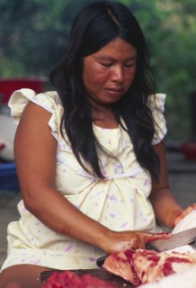 PERU, Departamento de Ucayali, Sepahua, Machiguenga indian woman preparing meat.