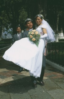 BOLIVIA, La Paz, Wedding in El Monticulo. Groom lifting up Bride.