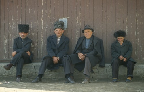 RUSSIA, Dagestan, Koubachi, ‘Gooderan’ meeting place.  Four men sitting along wall.