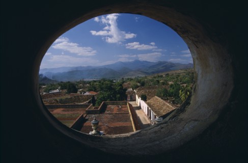 CUBA, Trinidad, View across red tiled city rooftops framed by oval window in Iglesia San Franciso