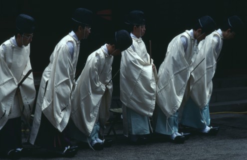 JAPAN, Honshu, Tochigi, Nikko.  Shinto priests watch and bow as the omikoshi or residence of the