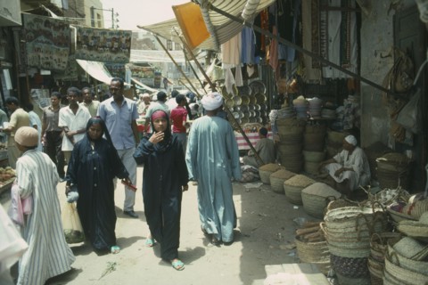 EGYPT, Aswan, Busy souk market scene with pulse vendor and crowds walking by.