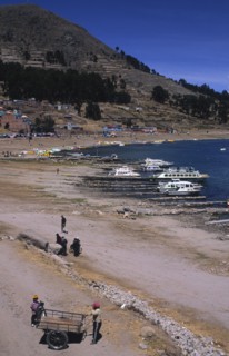 PERU, Puno, Lake Titicaca, Lake side scene with boats and people.