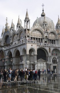ITALY, Veneto, Venice, Aqua Alta High Water flooding in St Marks Square with tourists walking on