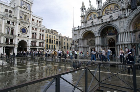 ITALY, Veneto, Venice, Aqua Alta High Water flooding in St Marks Square with tourists on elevated