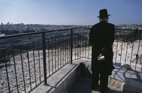 ISRAEL, Jerusalem, Elderly Ultra Orthodox Jewish man holding a bible in his hand surveying the