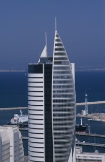 ISRAEL, Haifa, Tall modern fish shaped skyscraper with the docks and coastline seen in the