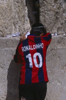 ISRAEL, Jerusalem, An Israeli boy wearing a Ronaldinho football shirt praying at the Western Wall.