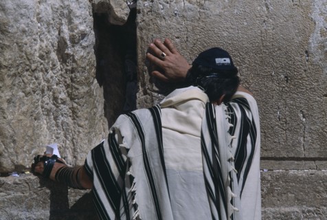 ISRAEL, Jerusalem, A Jewish man wearing a traditional prayer shawl praying at The Western Wall
