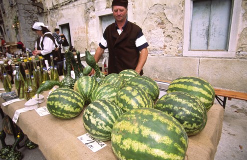 CROATIA, Istria, Buset, Man selling watermelons. The streets of old town Buzet are a riot of colour