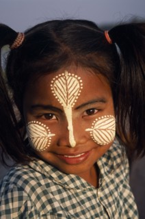 MYANMAR, Amarapura, Head and shoulders portrait of young girl at U Bein Bridge near Mandalay