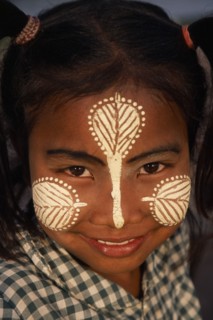 MYANMAR, Amarapura, Head and shoulders portrait of young girl at U Bein Bridge near Mandalay