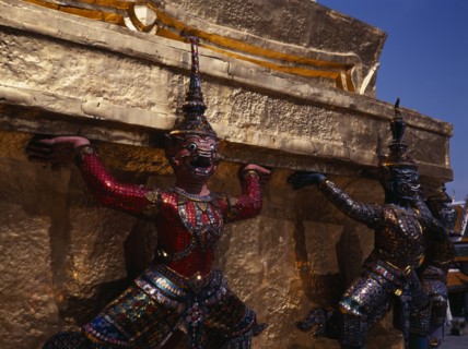 THAILAND, Bangkok, The Grand Palace.  Detail of figures encircling golden spire decorated with