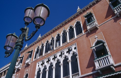 ITALY, Veneto, Venice, Terracotta and white painted facade of the Danieli Hotel with street lamp in