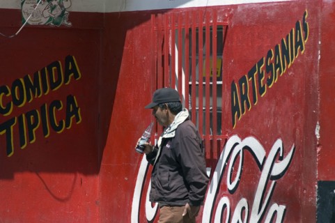 VENEZUELA, Merida state, Apartaderos, "Man drinking a soft drink next to a Coca Cola advert,