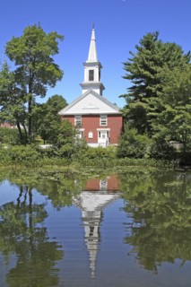 USA, New Hampshire, Harrisville, Community church refelected in pond.