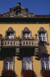 HUNGARY, Budapest, Detail of yellow painted facade of town building with stone balconies and window