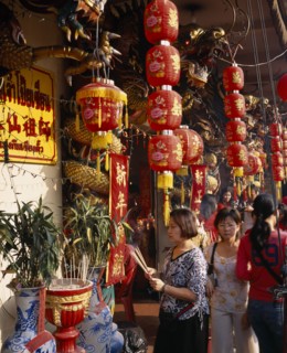 THAILAND, Bangkok, China Town, Wat Traimit.  People offering prayers and incense at temple