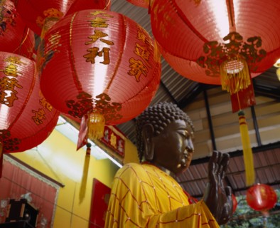 THAILAND, Bangkok, Sathorn District, Charoen Krung.  Buddha statue bathed and dressed in auspicious
