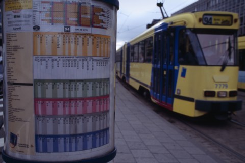 BELGIUM, Brabant, Brussels, Sign detailing tram times with passing tram beyond.