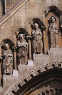 HUNGARY, Budapest, Benedictine Abbey of Jak. Detail of carved religious figures over stone archway.