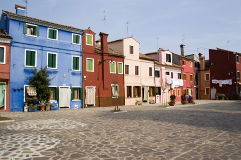 ITALY, Veneto, Venice, Colourful houses in a square on Burano. One of the few inhabited islands in