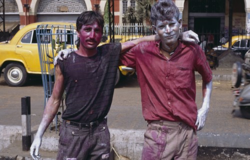 INDIA, West Bengal, Calcutta, Two young men covered in coloured paint during Holi celebrations.